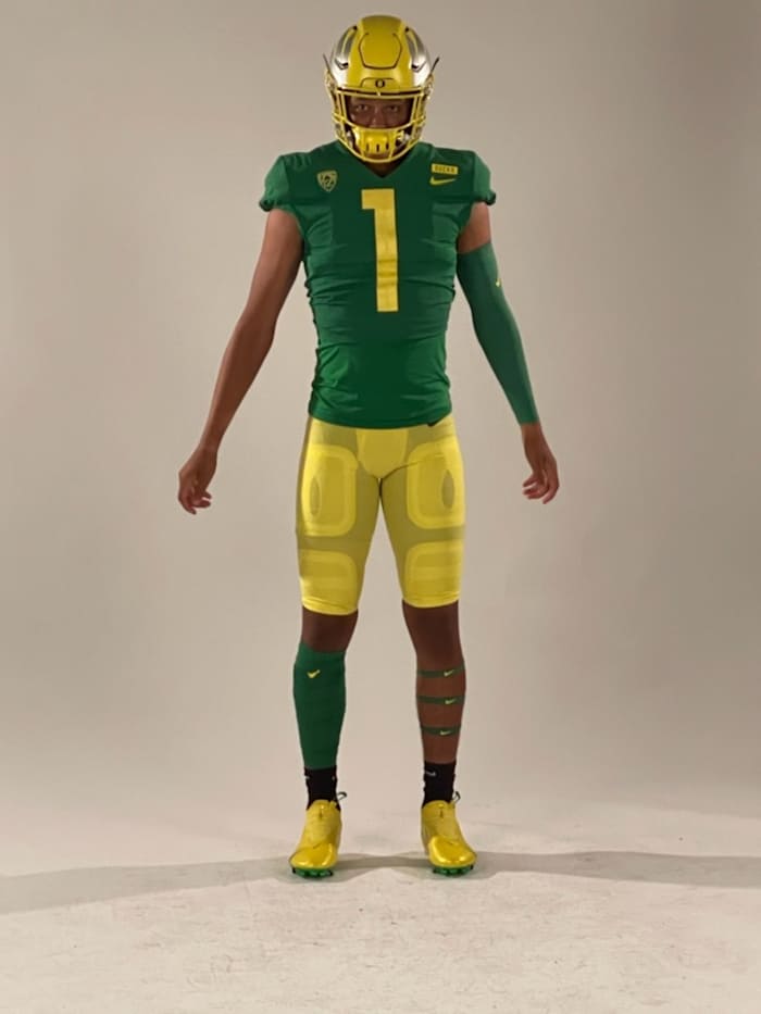 Austin Mack takes photos in the Ducks' apple green and yellow uniforms.